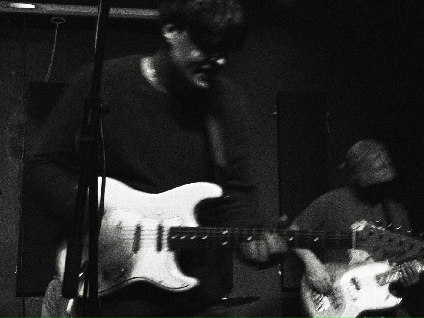 Black and white live shot of Ben on a white Stratocaster with Finn on bass behind him