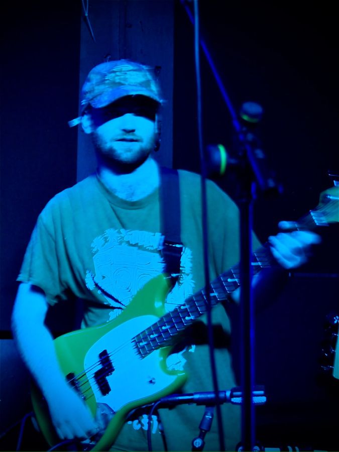 Finn Dunwell playing bass under blue light