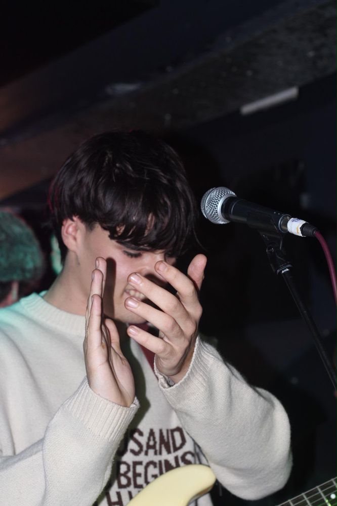 Ben laughing on stage with his hands raised