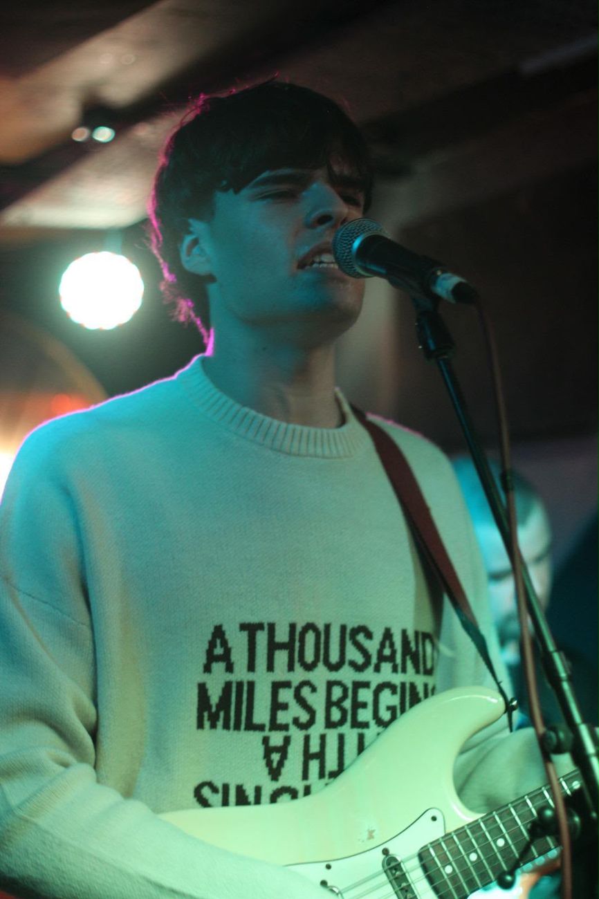 Ben singing at the microphone with a cream Stratocaster at Mr Wolf's, Bristol